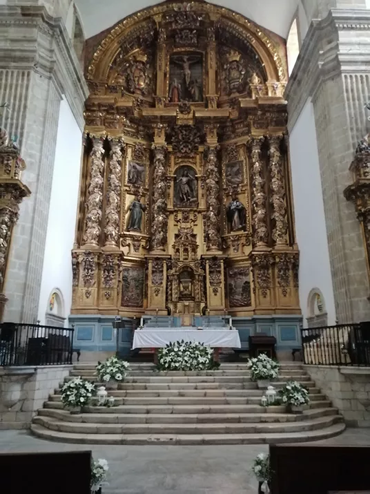 Altar de una iglesia decorado con flores blancas